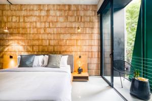 a bedroom with a bed and a wooden wall at UTOPIC Roma Norte by ULIV in Mexico City