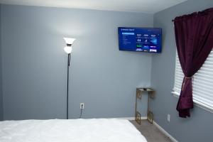 1 dormitorio con cama blanca y pared azul en Heart of Raleigh en Raleigh