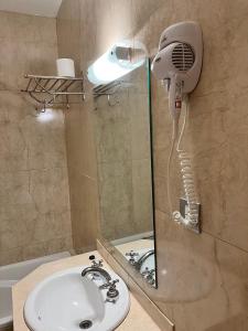 ein Badezimmer mit Dusche und Föhn in der Unterkunft Bristol Hotel in Buenos Aires + 58 Fotos