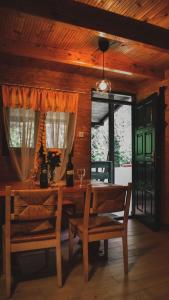 a dining room with a wooden table and two chairs at Vikendica,, Tadic,, Ovčar Banja in Ovčar Banja