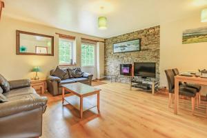 ein Wohnzimmer mit Sofa und Fernseher in der Unterkunft Stable Cottage in Ilfracombe