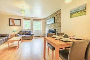a living room with a table and a dining room at Stable Cottage in Ilfracombe