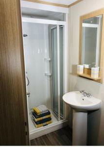 a bathroom with a glass shower and a sink at The Secret Wood in Swarland