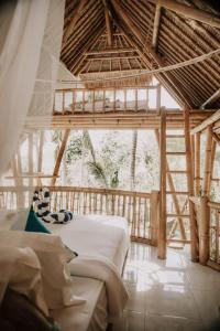 um quarto com uma cama grande numa casa de bambu em La royale Romantic Bamboo Villas em Klungkung