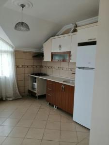トラブゾンにあるYAFA Furnished Apartments Trabzonのキッチン(白いキャビネット、冷蔵庫付)