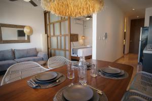 a dining room with a table with chairs and a couch at IPANA Luxury Apartments by Vacaciones.Yeah in Playa del Carmen