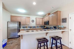 a kitchen with wooden cabinets and a stainless steel refrigerator at Willard Lake House in Bass Lake