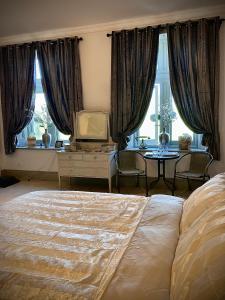 a bedroom with a bed and a table and windows at Trawscoed Mansion,Central Wing in Aberystwyth