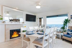 a dining room with a table and a fireplace at Brink of Paradise in Carpinteria