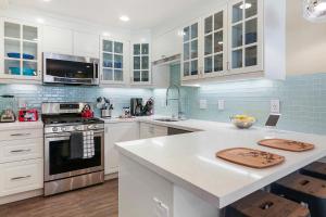 a kitchen with white cabinets and a counter top at Doorstep to Disneyland Condos in Anaheim