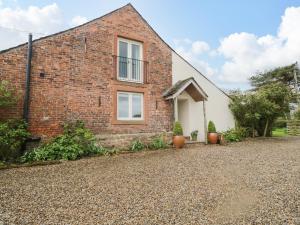 a brick house with two potted plants in front of it at Stockwell Hall Cottage in Sebergham