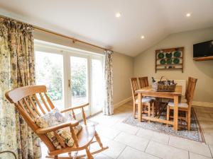 sala de estar con mesa, sillas y ventana en Stockwell Hall Cottage, en Sebergham