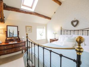 an attic bedroom with a bed and a mirror at Stockwell Hall Cottage in Sebergham