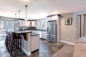 uma cozinha com armários brancos e um frigorífico de aço inoxidável em Skyline Manor em South Lake Tahoe