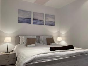 a bedroom with a large bed with three paintings on the wall at Casa di Giorgio in Jelsa