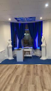 a room with blue curtains and a wooden floor at The Adonis Hotel in Blackpool