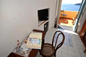a wooden table with a book and a television at Hotel La Casa sul Mare in Procida