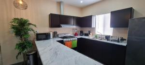 a kitchen with black cabinets and a white counter top at super condo with fiber optic internet in Puerto Peñasco