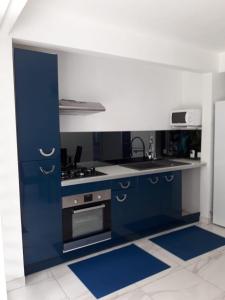 uma cozinha com armários azuis e um fogão em JONA APT em Le Lamentin