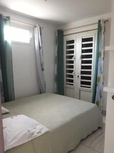 Un dormitorio con una cama grande y una ventana en JONA APT en Le Lamentin