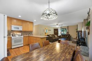 uma cozinha e sala de estar com uma mesa de madeira e cadeiras em Atroari Adventures em South Lake Tahoe