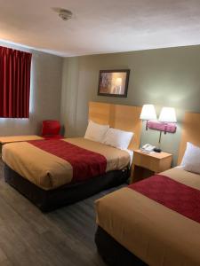 een hotelkamer met 2 bedden en 2 lampen bij FALLS INN in Newton Falls