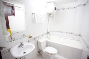 a white bathroom with a toilet and a sink at Hồng Phát Hostel in Hue +9 photos