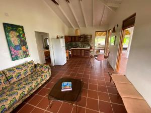 a living room with a couch and a table at Sea Cliff Eco-Cottages & Gin Distillery in Calibishie