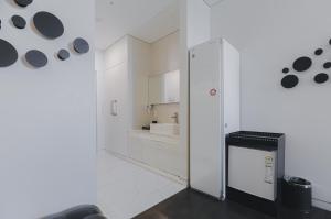 a white kitchen with a refrigerator and a sink at ACC Design Hotel in Gwangju