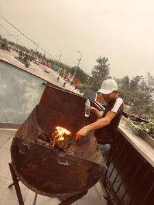Un uomo che cuoce sul fuoco in una griglia di RiverView Homestay 2 a Xóm Ðé