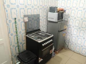 a small kitchen with a stove and a microwave at HEBERTOGO TOKOIN CASABLANCA in Lomé