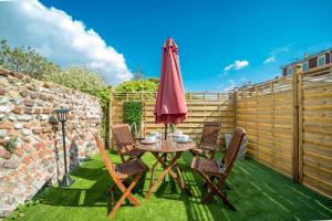 a table and chairs with an umbrella on the grass at Luxury Brighton Apartments in Brighton & Hove