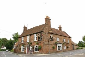 an old brick building on the corner of a street at The George & Horn near Newbury in Kingsclere