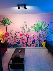a living room with a mural of flowers and birds at Pink Tropical Champagne in Reims