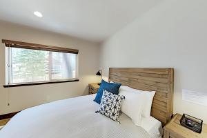 een slaapkamer met een groot wit bed met blauwe kussens bij Prospector Palace in South Lake Tahoe