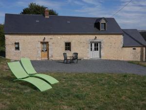 una casa con una sedia verde davanti di Chaleureux gîte aux portes de l'histoire a Agy