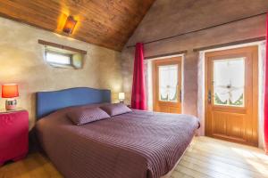 a bedroom with a bed and two windows at Chaleureux gîte aux portes de l'histoire in Agy