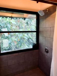 a bathroom with a large window in a shower at Casa NATIVO in Jardin