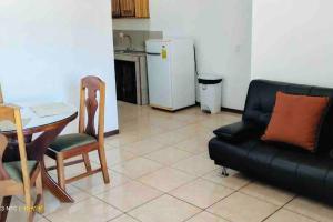 a living room with a couch and a chair and a table at Puntarenas, Apartamento a 25 metros del mar, cerca del hospital in Puntarenas