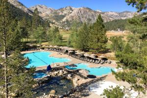 an aerial view of a resort pool with mountains in the background at Resort at Squaw Creek's 605 in Olympic Valley