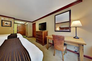 a bedroom with a bed and a desk and a television at Resort at Squaw Creek's 605 in Olympic Valley