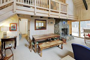 uma sala de estar com uma mesa e uma lareira de pedra em Alpine Haven em Tahoe City