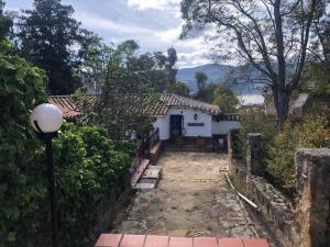 ein kleines weißes Haus mit Straßenbeleuchtung davor in der Unterkunft La Ronda in Guatavita