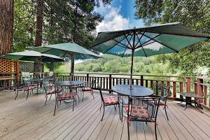 a group of tables and chairs with umbrellas on a deck at Villa Eileen in Guerneville
