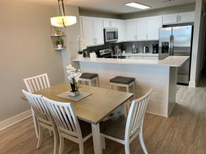 a kitchen with a wooden table and chairs and a counter at Sunset Cove at Calypso III in Panama City Beach