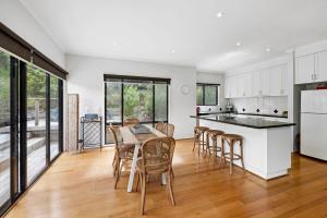 a kitchen and dining room with a table and chairs at Hidden Gem in Lorne