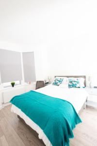 クロイドンにあるDunamis Staycation 1のベッドルーム1室(緑の毛布付きのベッド1台付)