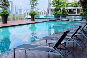 a swimming pool with lounge chairs on a building at The Pearl Kuala Lumpur in Kuala Lumpur