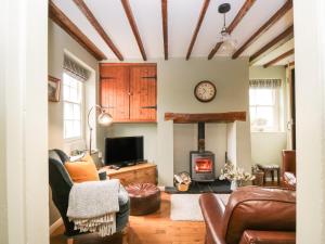 a living room with a couch and a fireplace at Beckside Cottage in Welton
