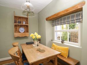 jadalnia z drewnianym stołem i krzesłami w obiekcie Beckside Cottage w mieście Welton